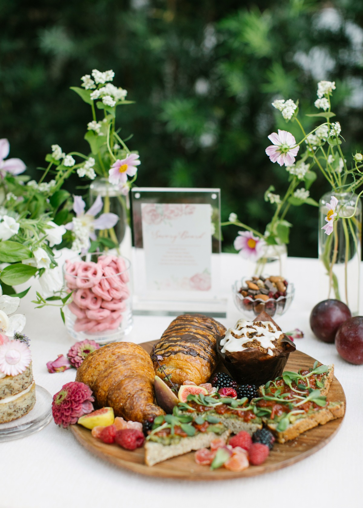 Elegant brunch spread with pastries, fruits, and flowers on a table