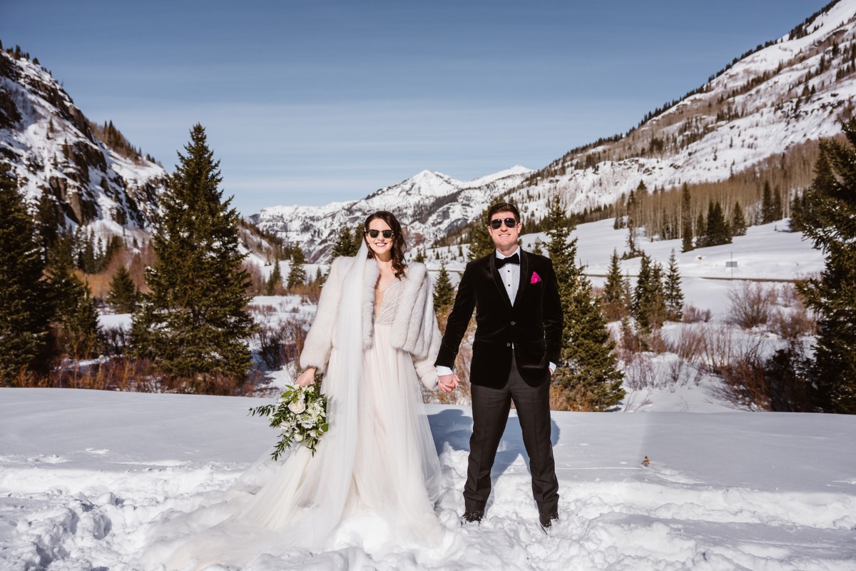 Newlyweds pose in the snow-covered mountains on their wedding day