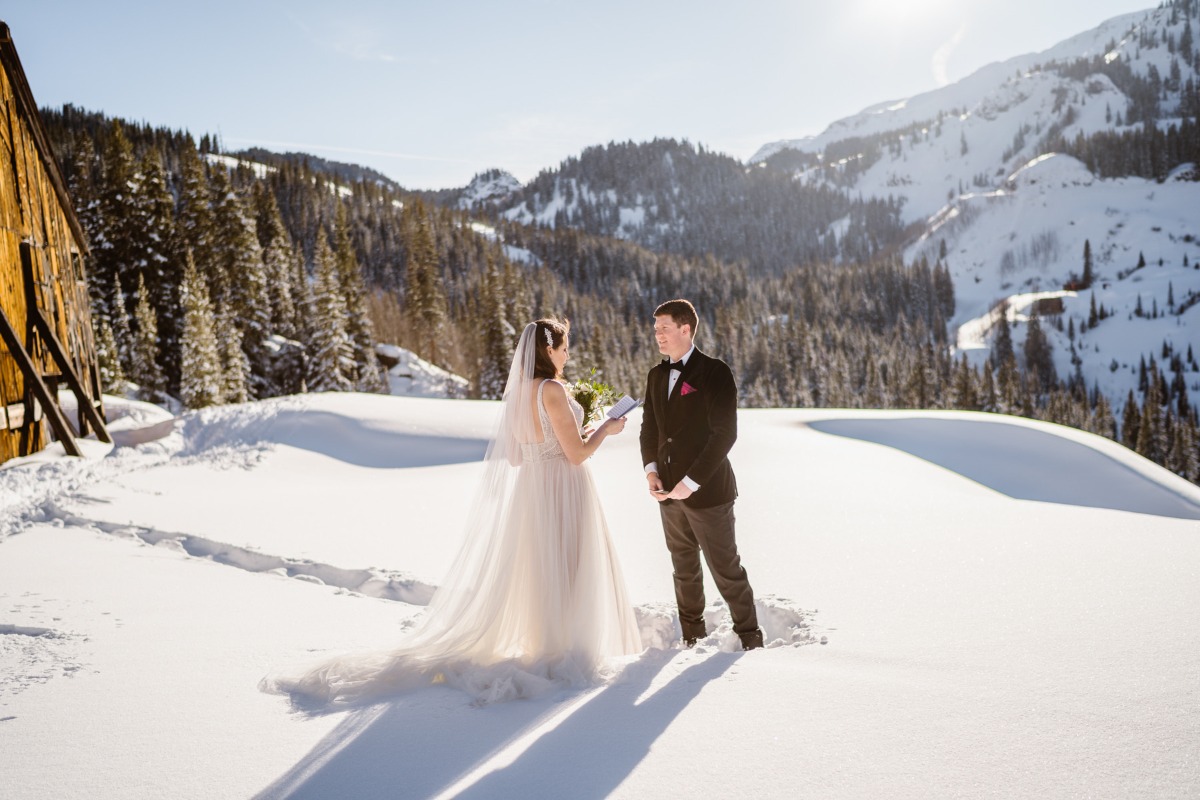 Couple exchanging vows in snowy mountains on their wedding day