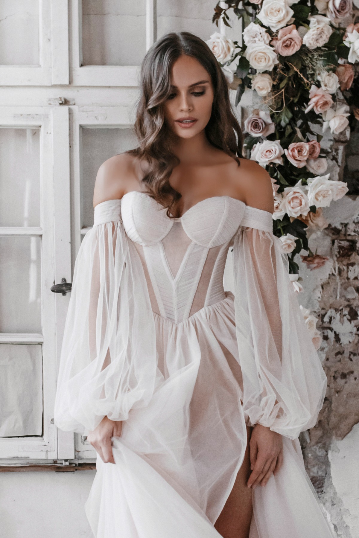 Elegant bride in off-the-shoulder gown with sheer sleeves and skirt