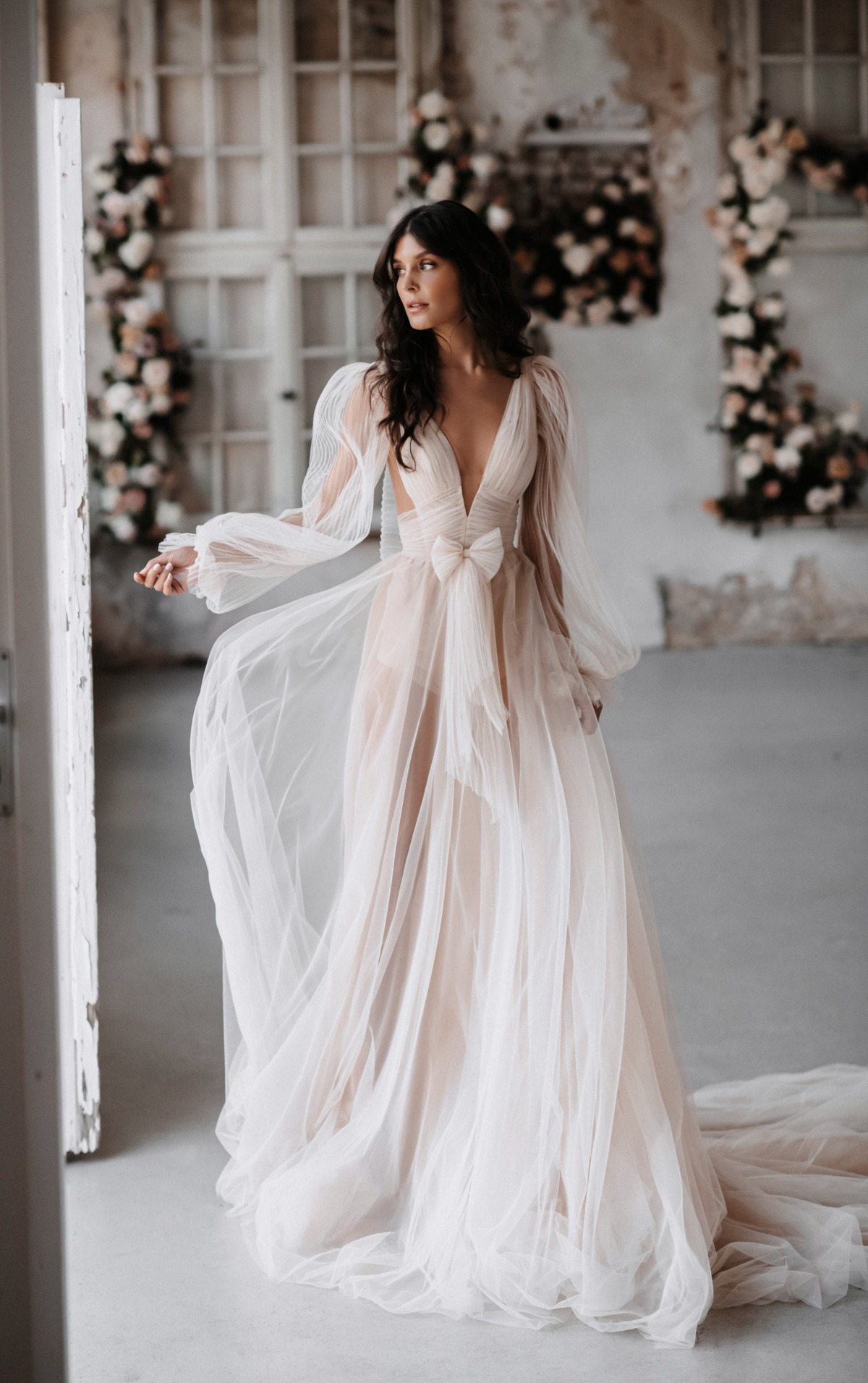 Elegant bride in a flowing tulle wedding dress with long sleeves