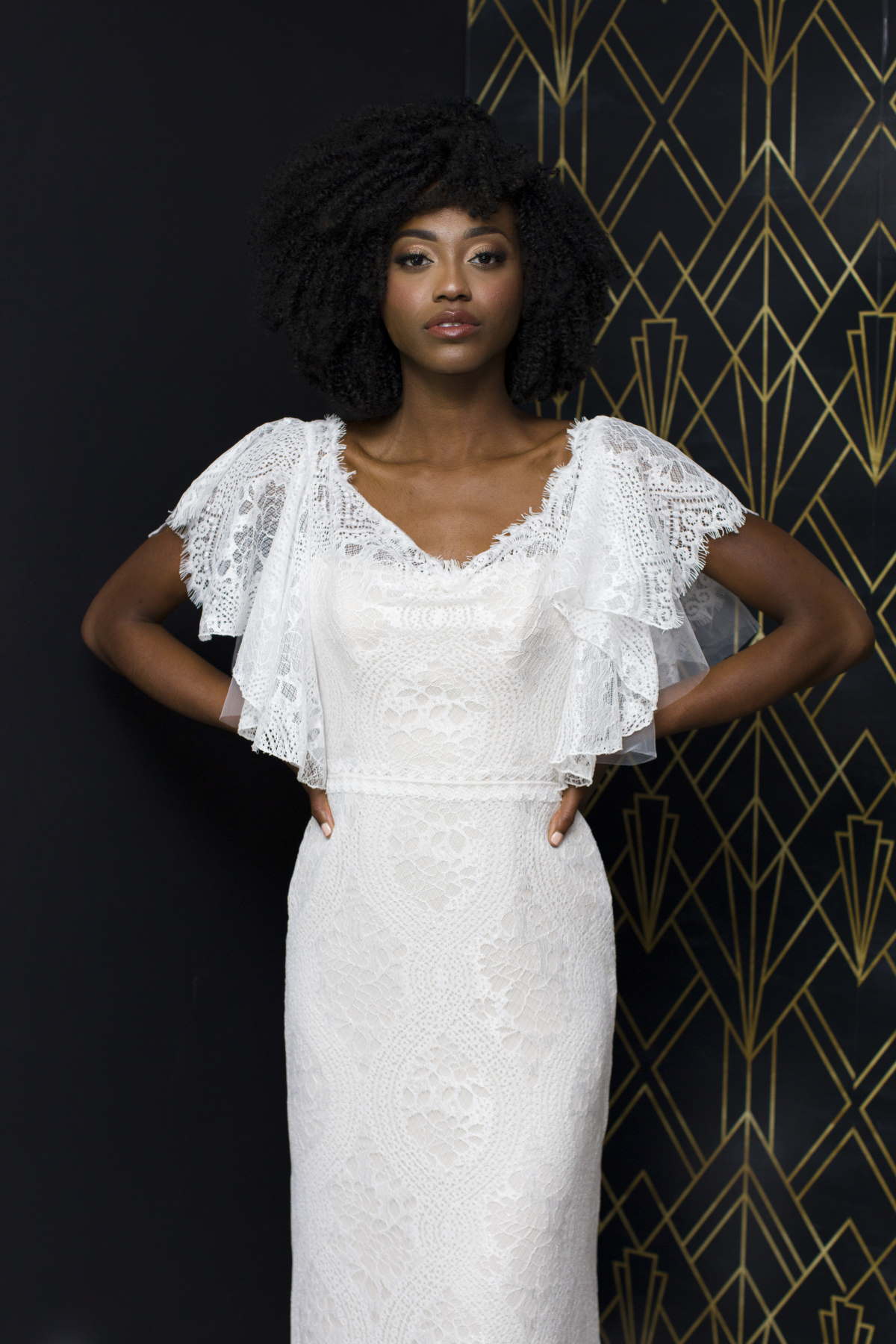 Elegant bride in a lace wedding dress with cap sleeves posing