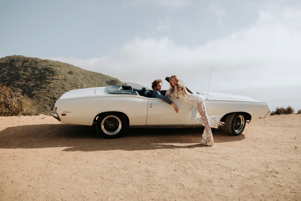 Couple in a vintage convertible posing for a photo shoot outdoors