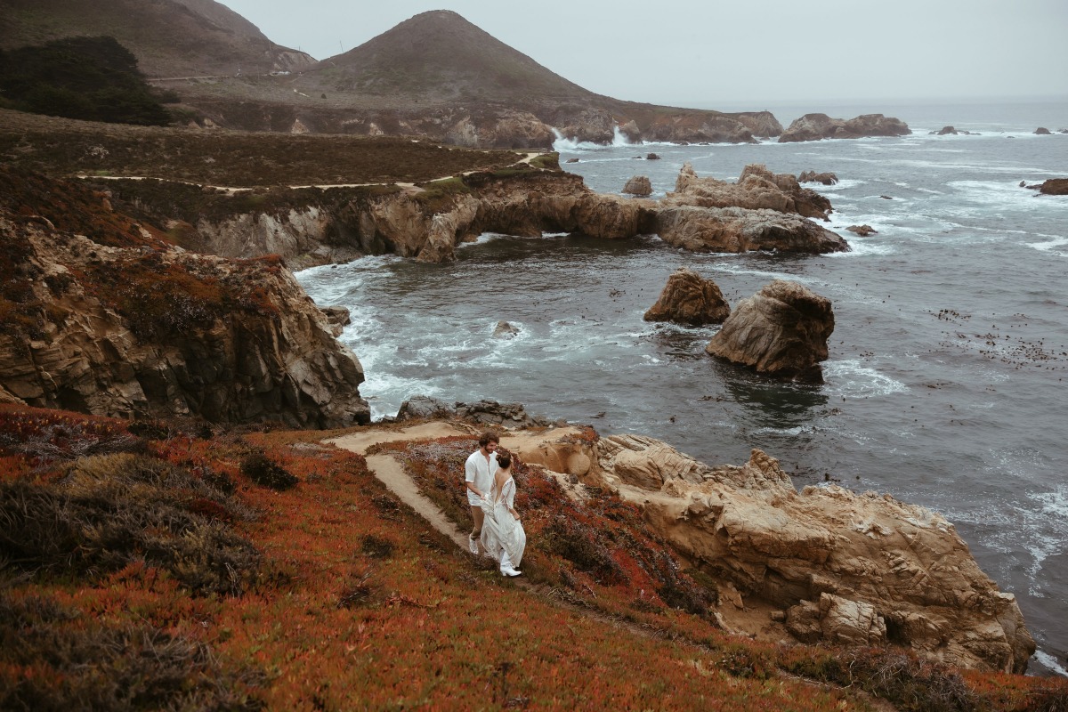 Couple walks along scenic coastal path with ocean view