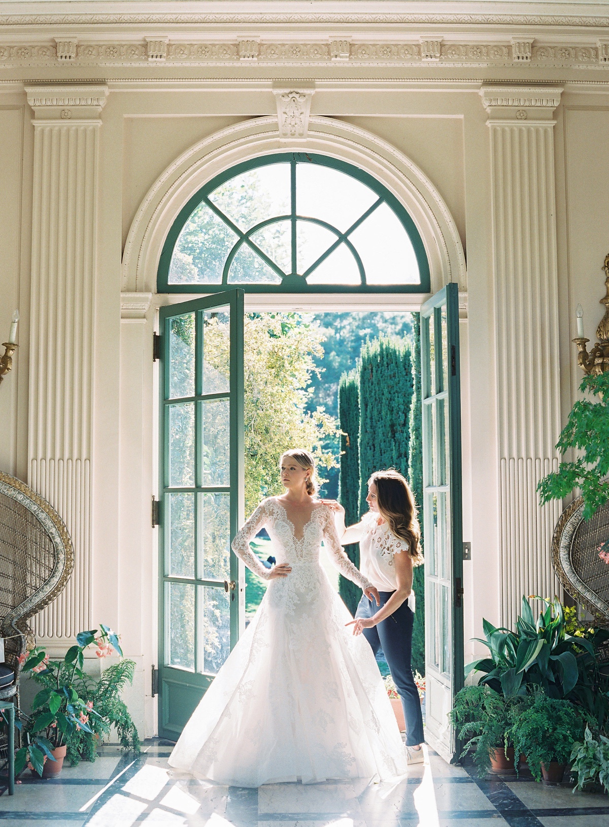 Bride in a wedding dress by the open door getting ready