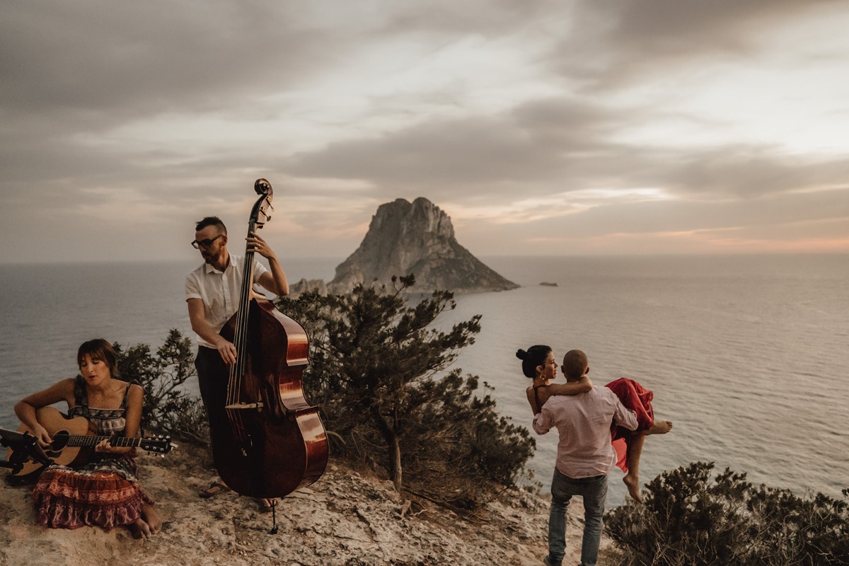 Couple dancing on cliff with music and scenic sea background