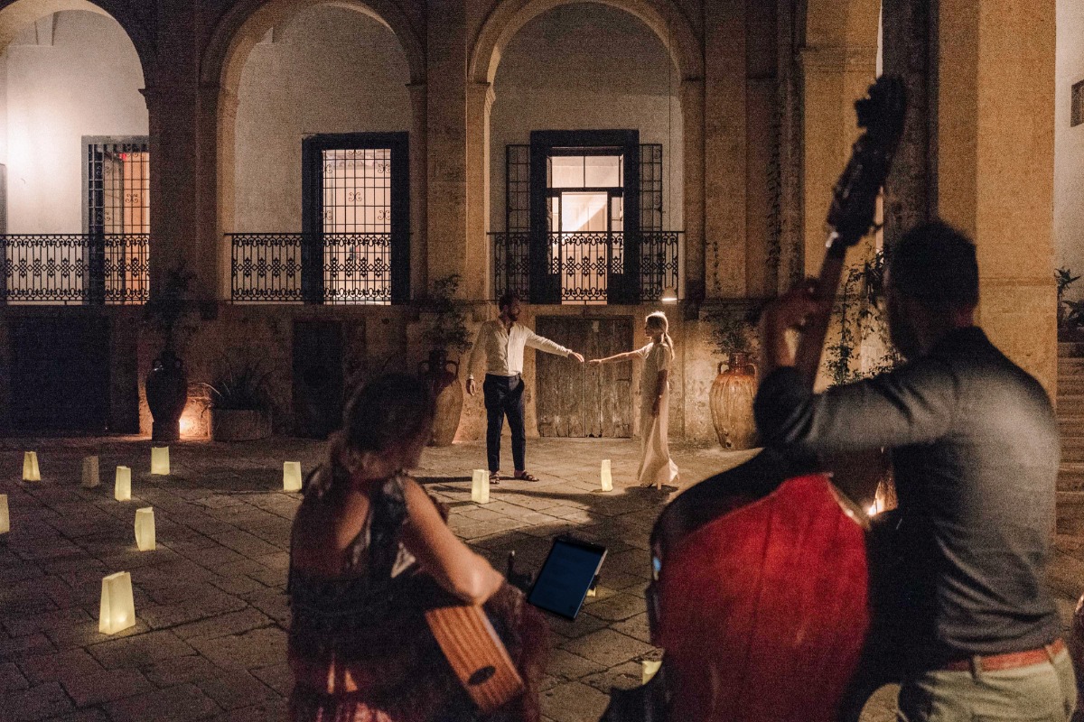 Romantic couple dancing in an open space with live music, at night