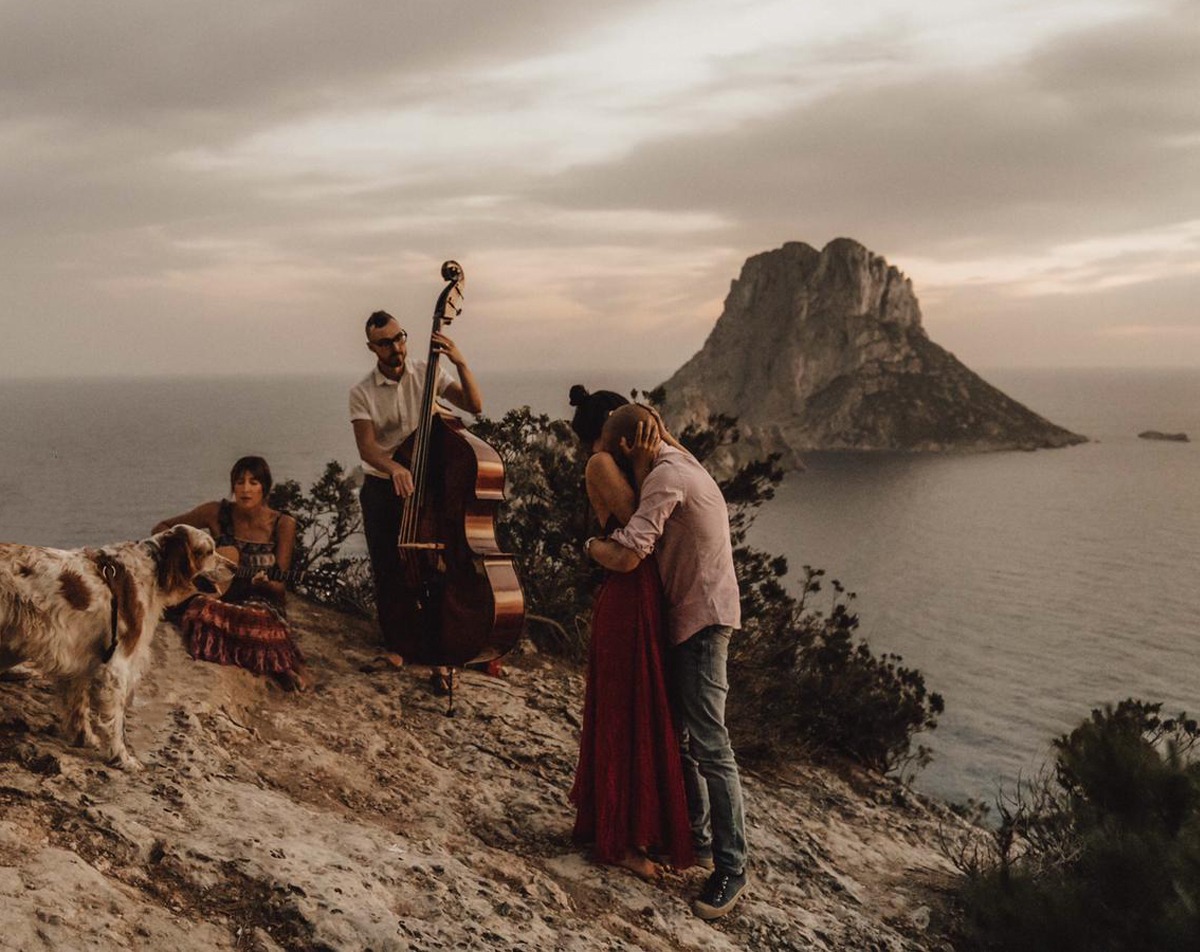 Romantic moment with musicians on a cliff overlooking the ocean