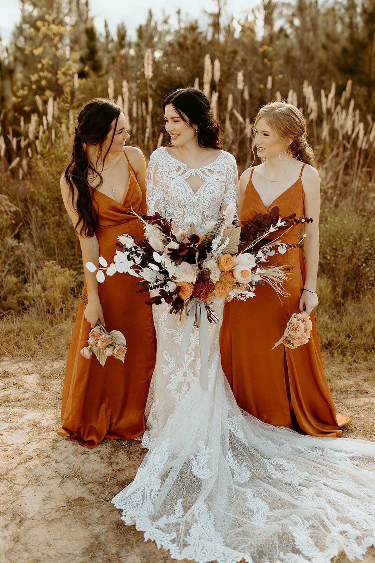 Bride with bridesmaids in orange dresses posing for a wedding photo