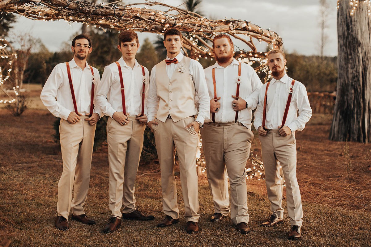 Group of groomsmen posing for a wedding photo outdoors