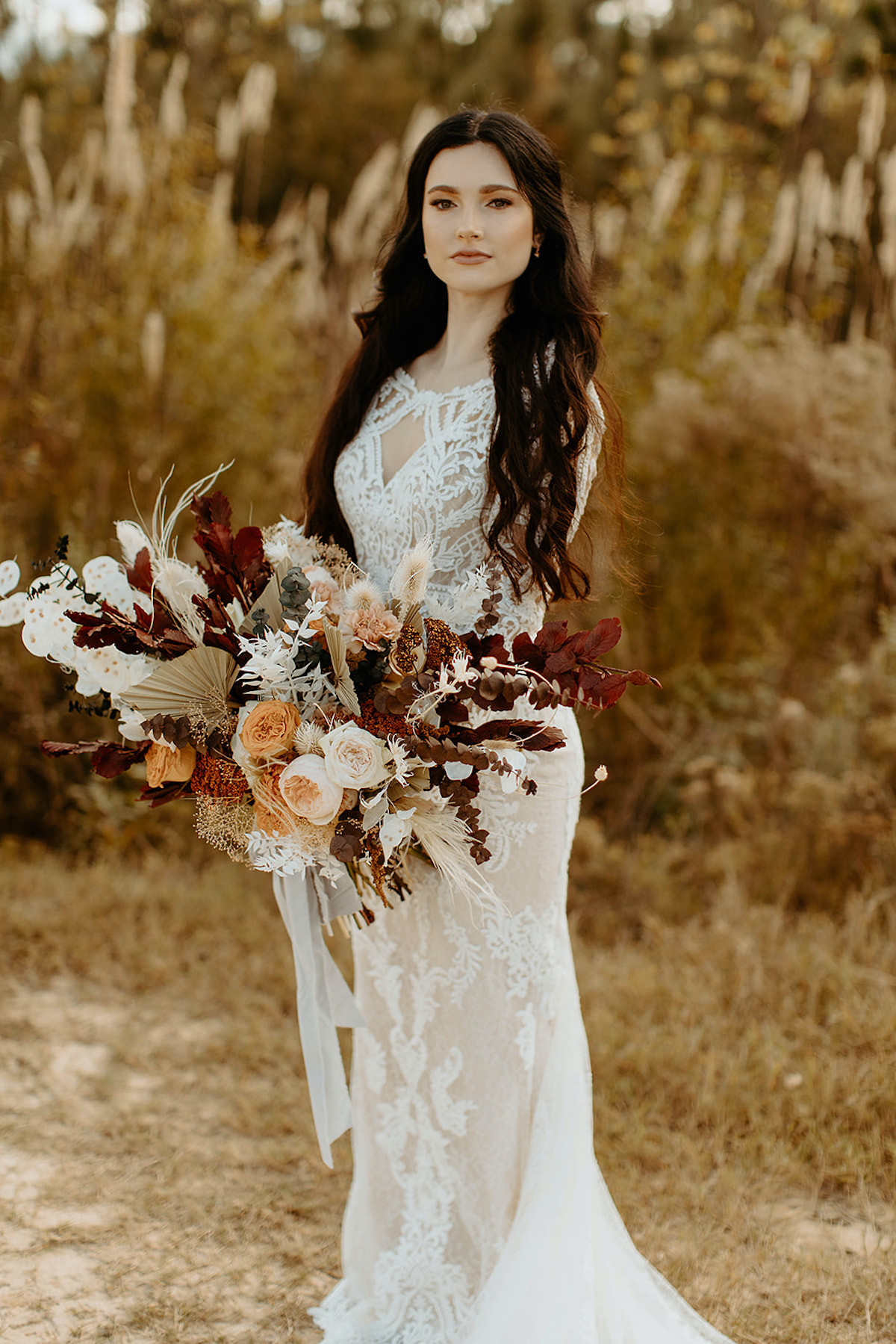 Bride in a lace wedding dress holding a bouquet of flowers