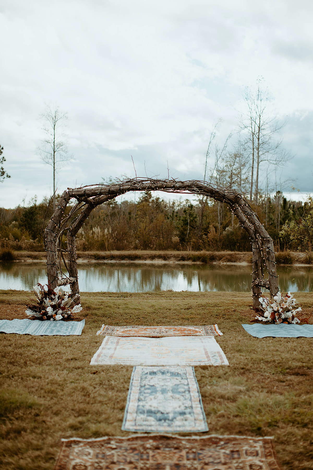 Rustic wedding arch overlooking a serene pond and lake