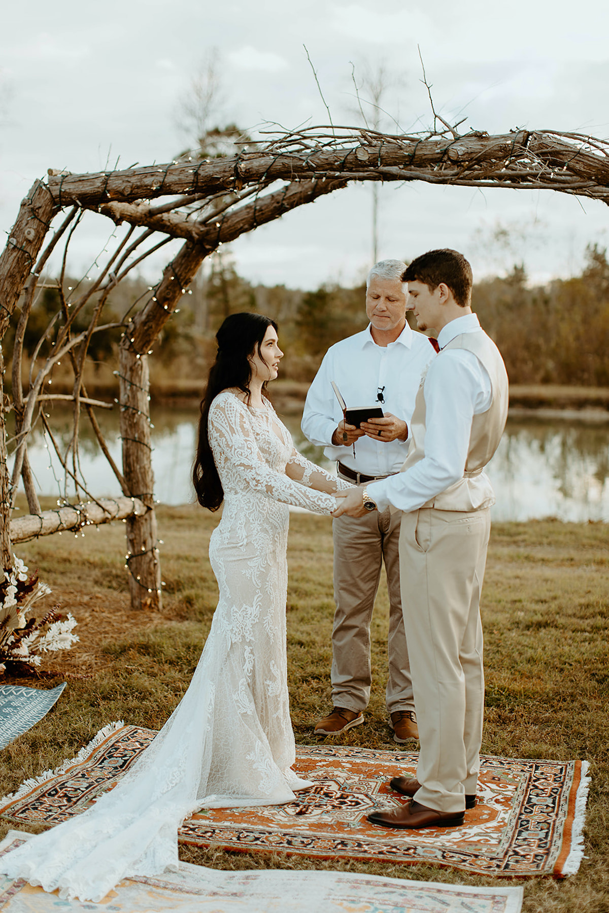 Wedding ceremony outdoors under a rustic wooden arch