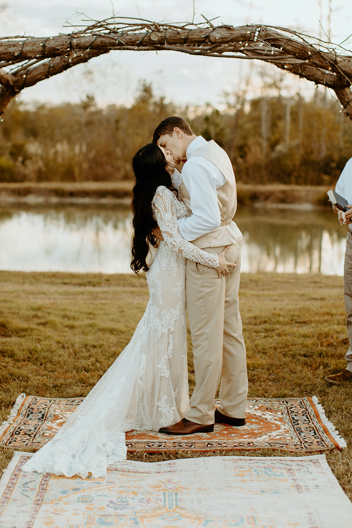 Bride and groom share a passionate kiss during outdoor wedding ceremony