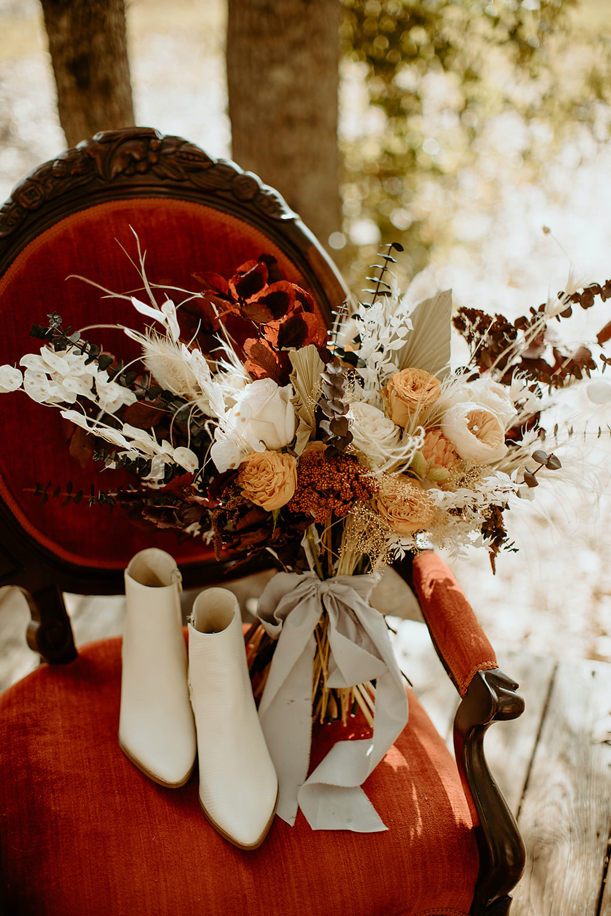 Elegant wedding bouquet and boots on a vintage chair for a rustic theme
