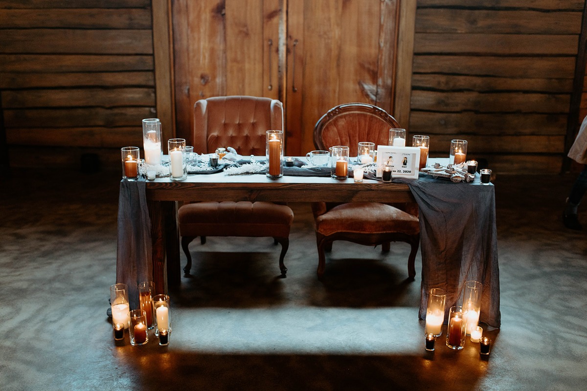 Romantic wedding table decor with candles, chairs and wooden table