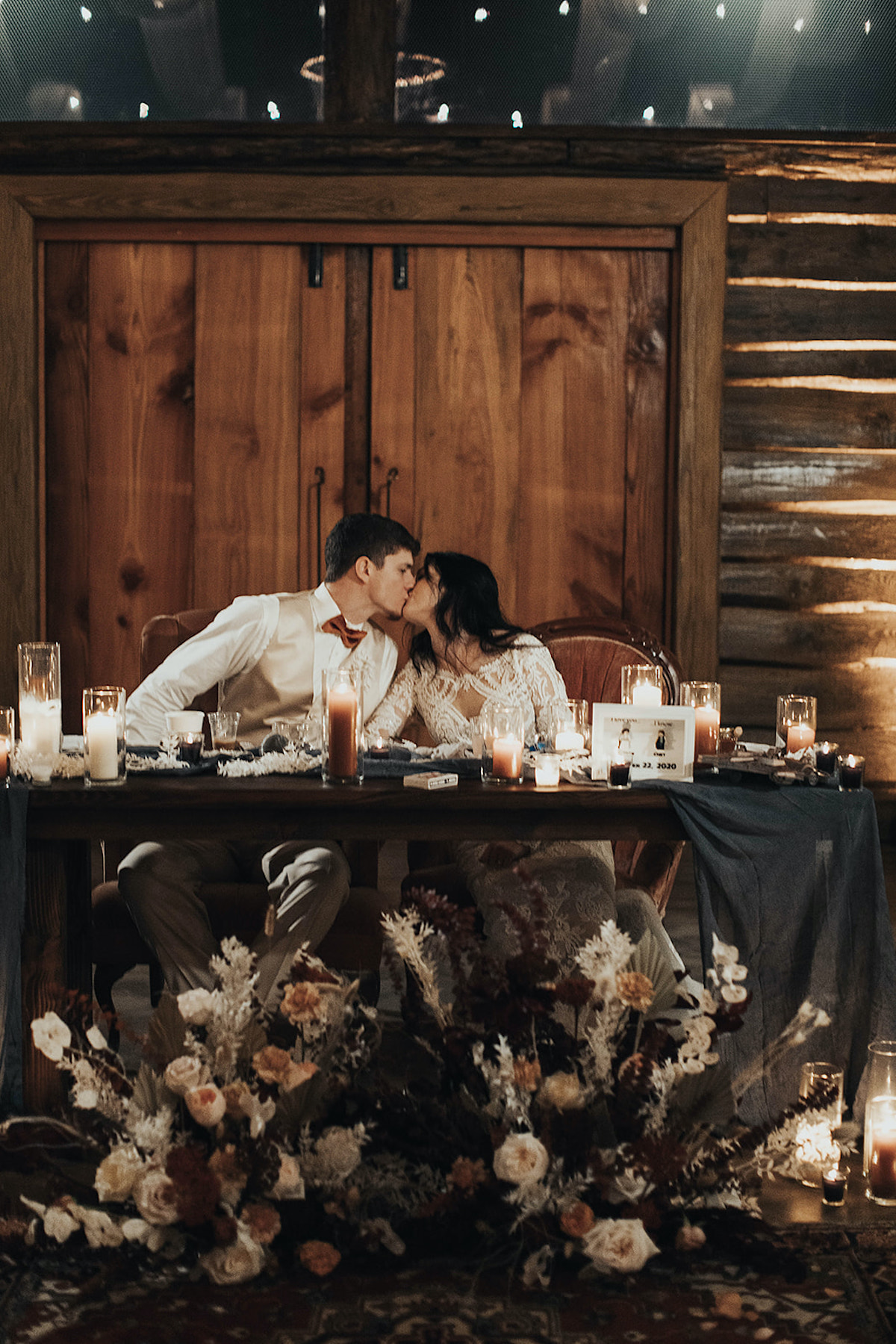 Romantic wedding couple kissing with flowers and candles