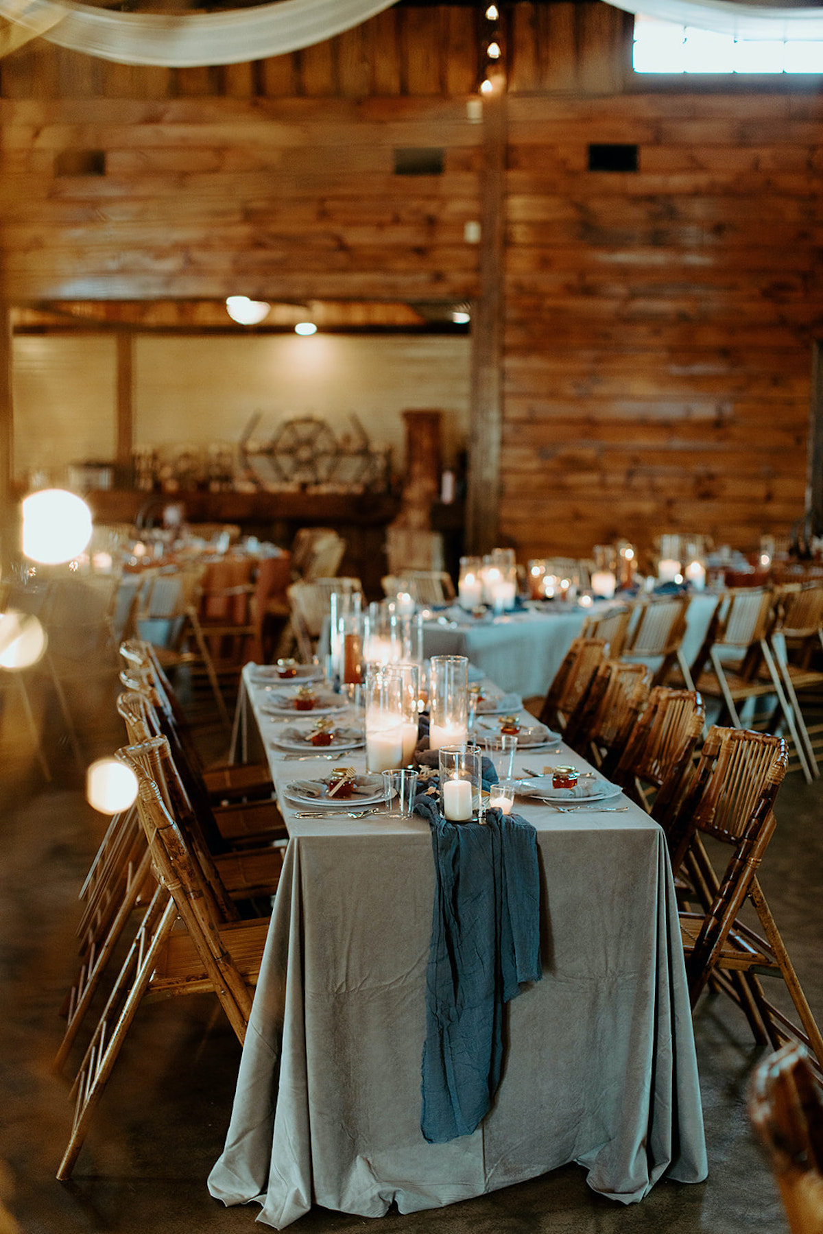 Wedding reception table setting in a rustic, wooden venue