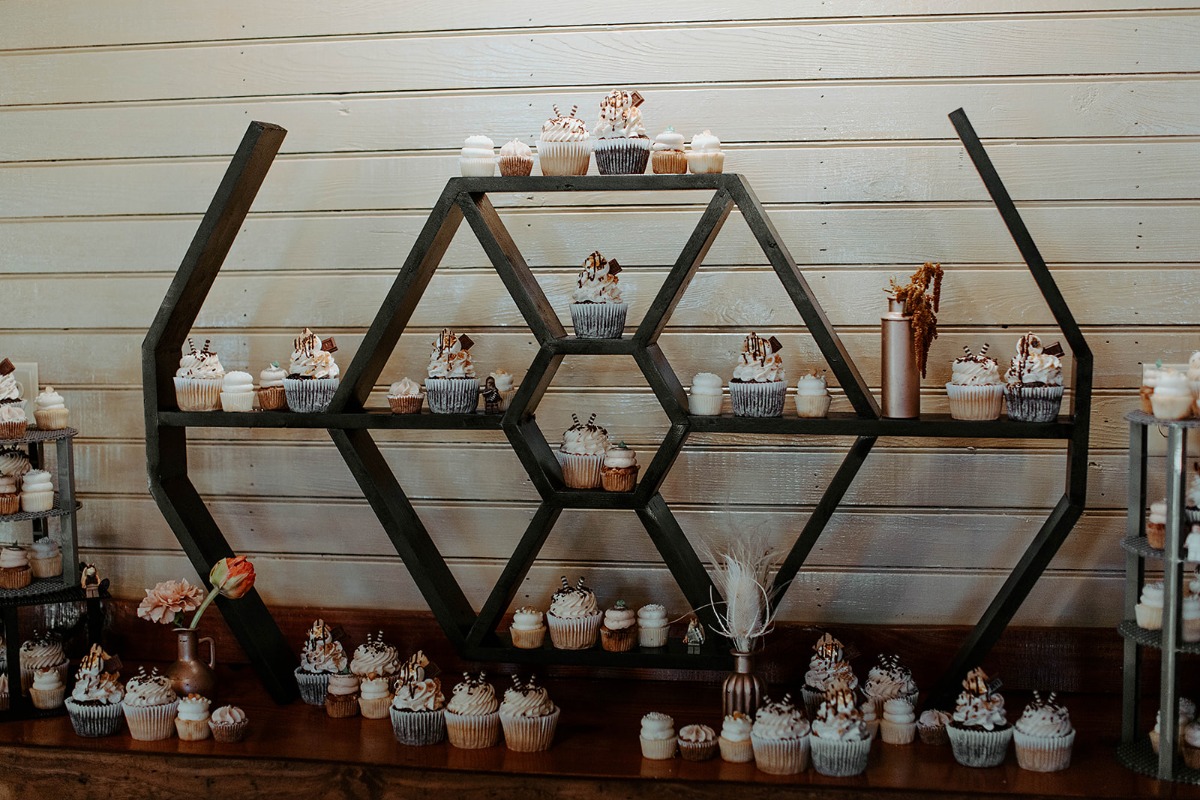 Cupcakes displayed on a geometric shelf at a wedding reception