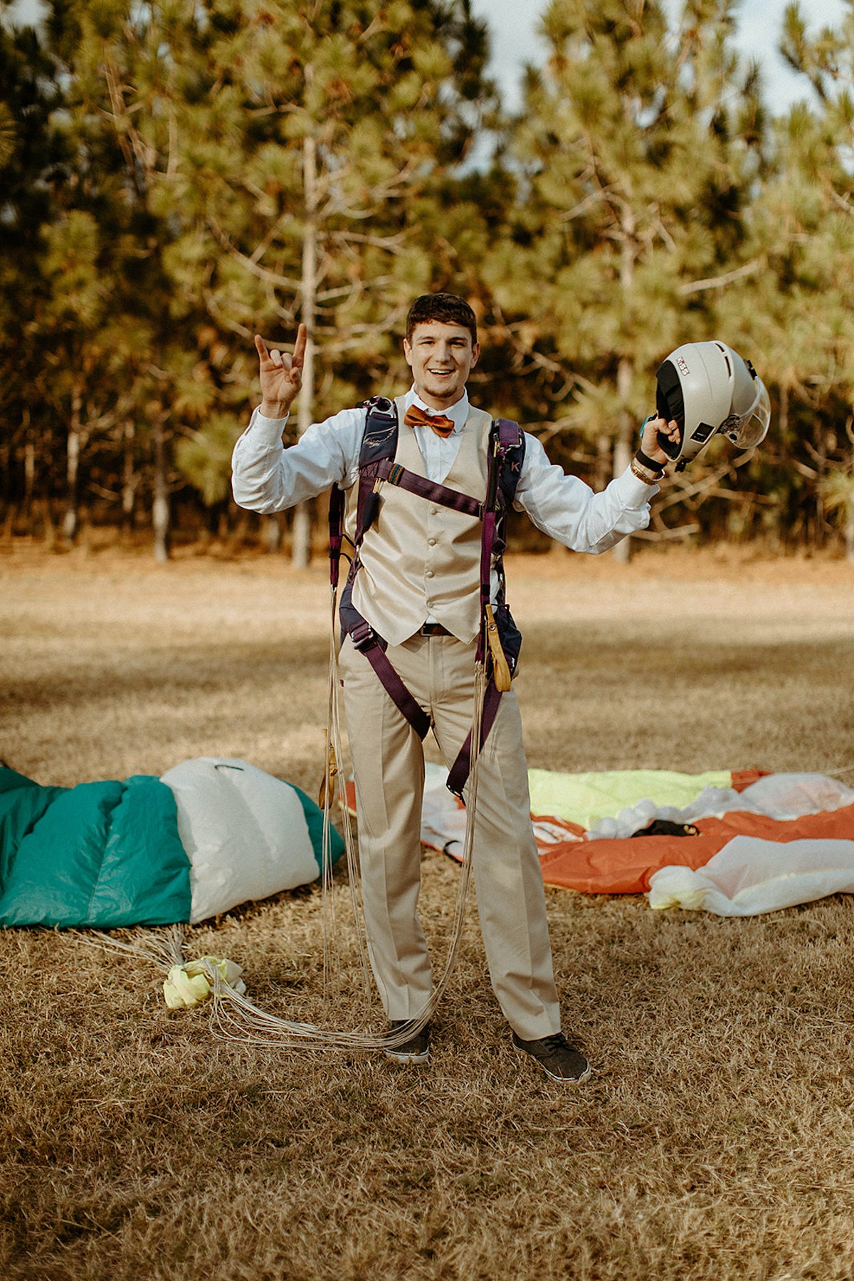 Smiling man in formal wear preparing for a parachute jump
