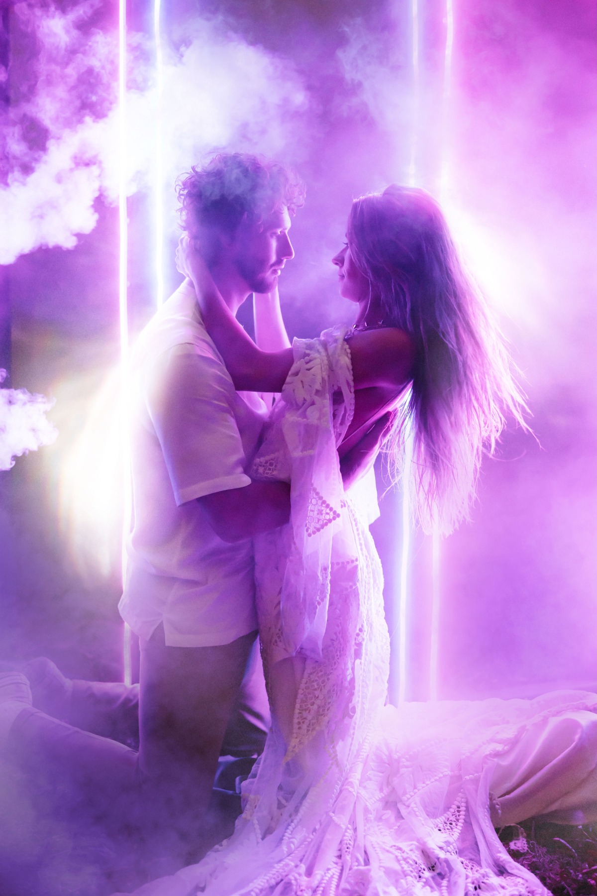 Romantic couple in purple neon light embracing intimately