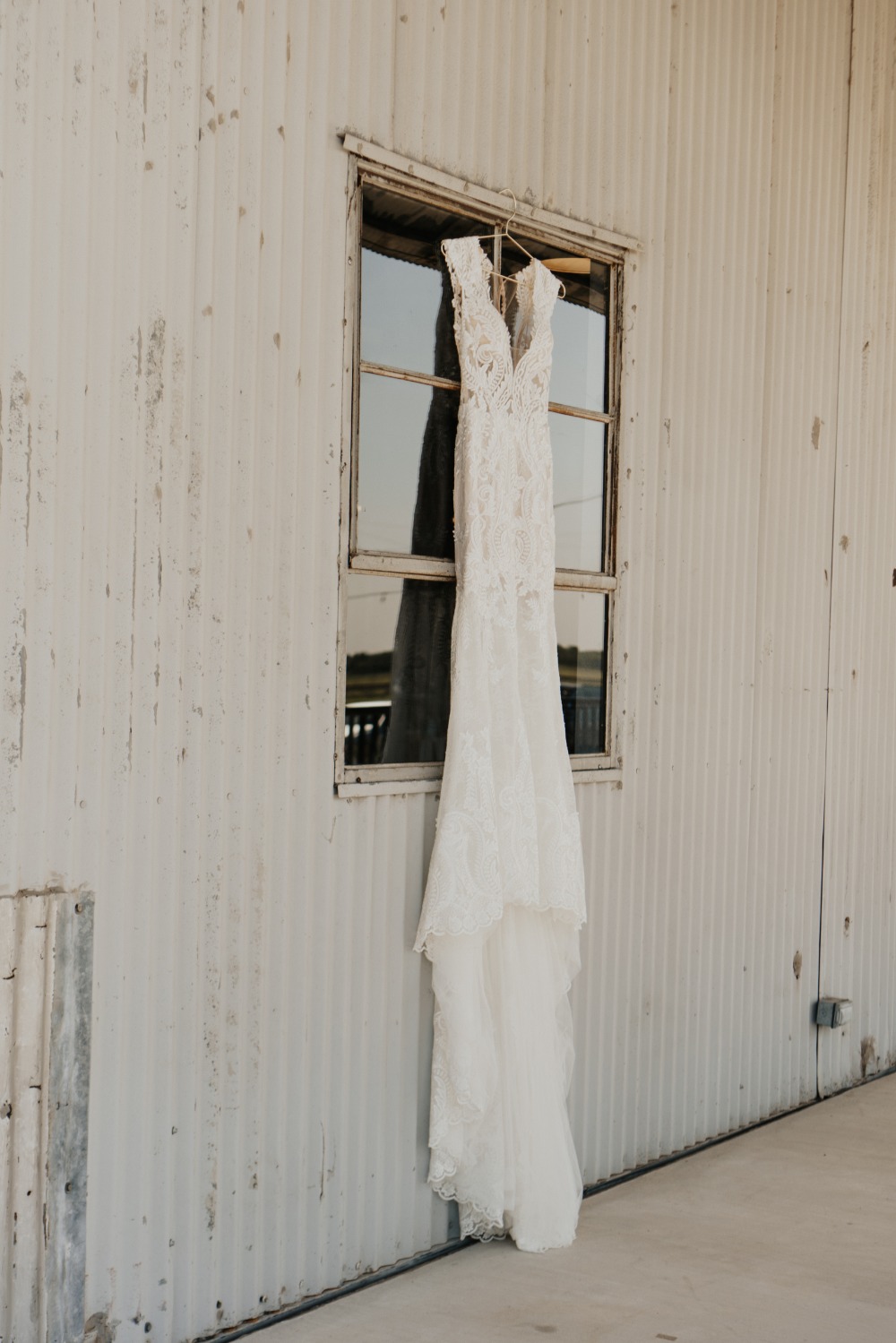 Elegant wedding dress hanging in a window waiting for the big day