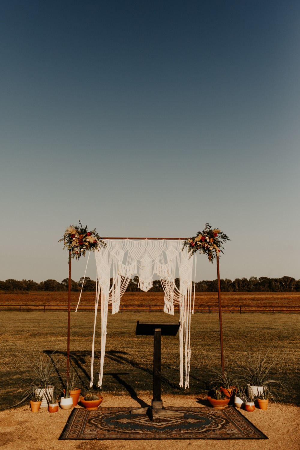 Rustic outdoor wedding arch with macrame and flowers