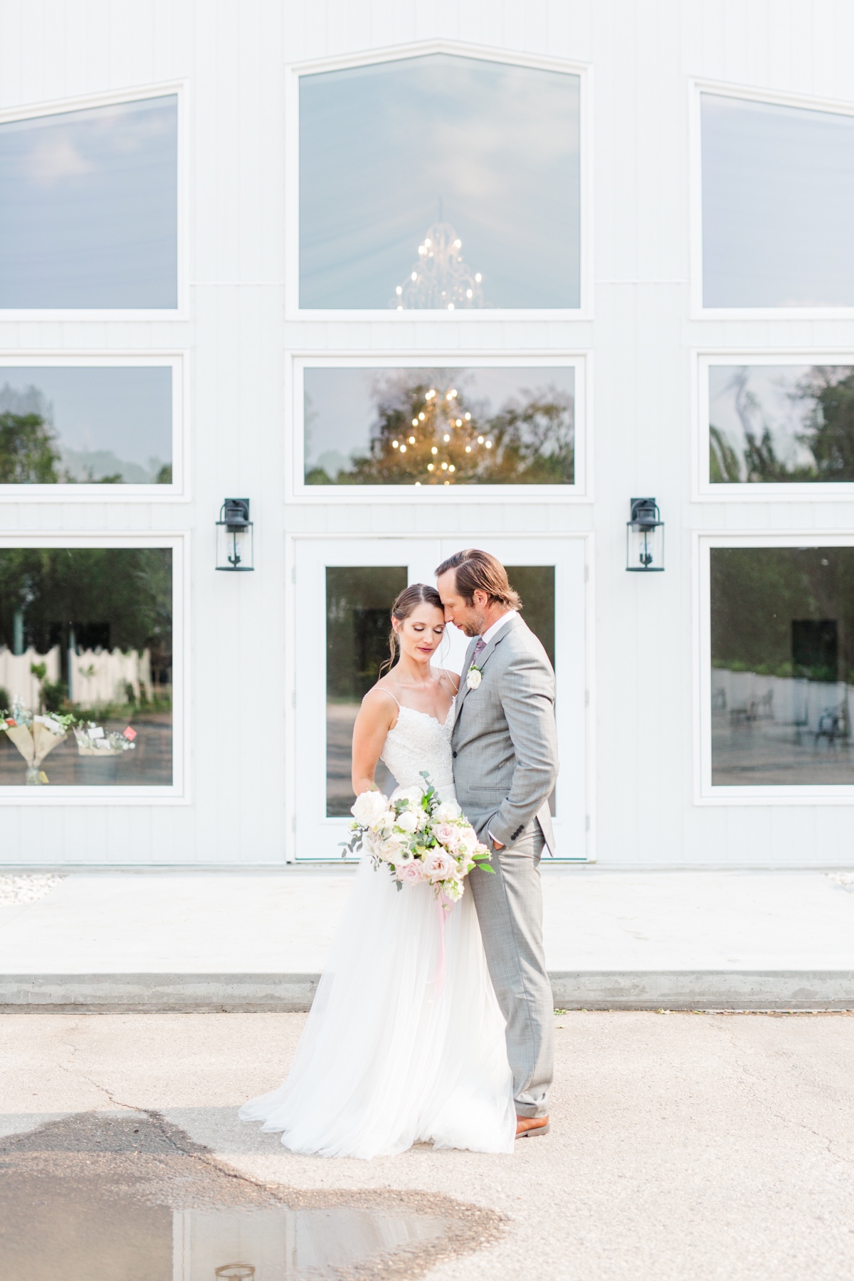 Newlyweds embrace outside a wedding venue, a beautiful moment