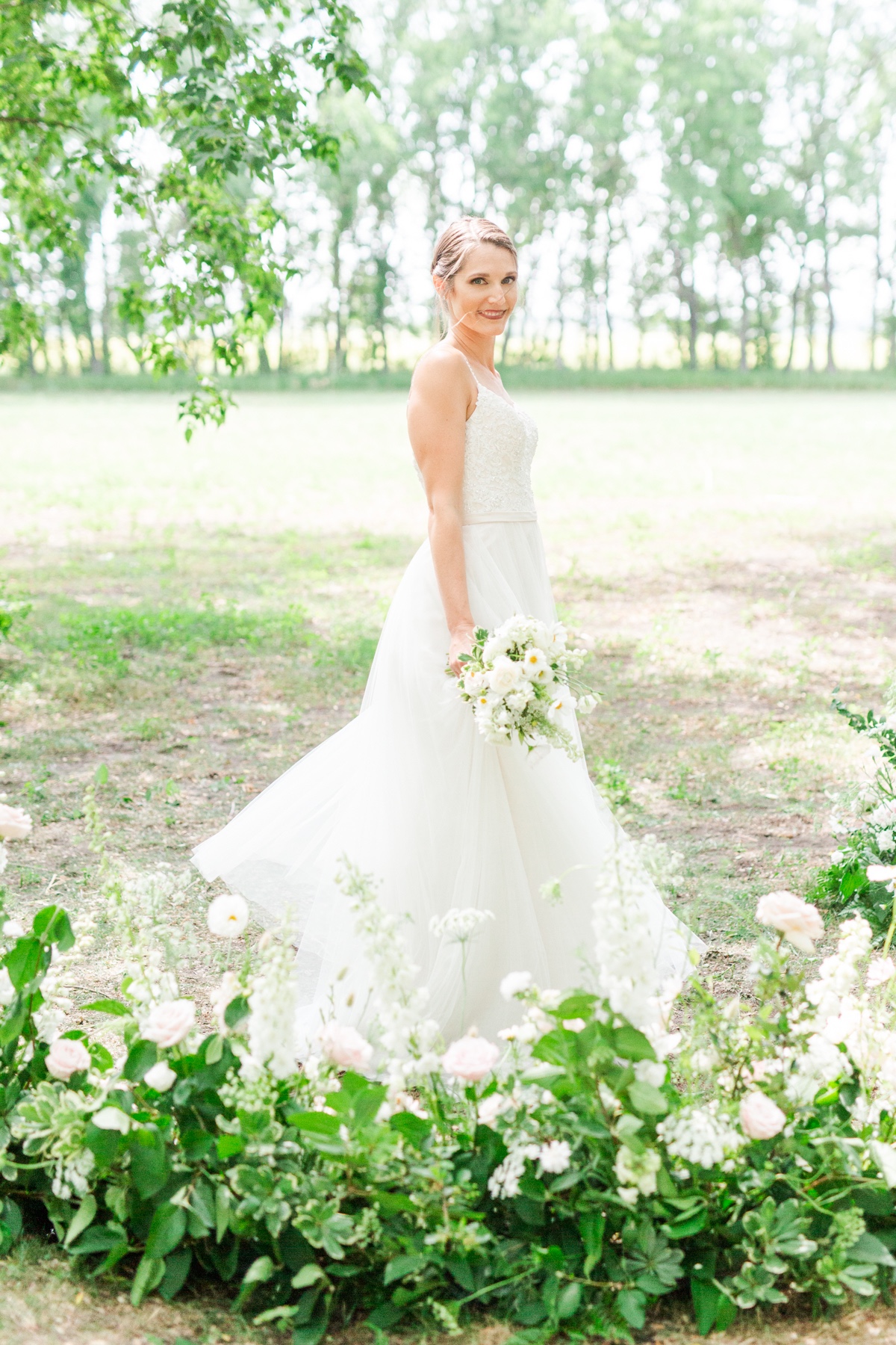 Beautiful bride smiling, holding flowers on her wedding day