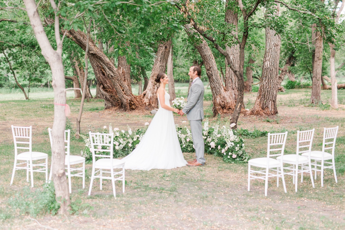 A couple holding hands at an outdoor wedding ceremony