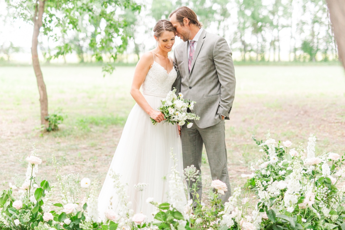Happy couple on their wedding day surrounded by flowers
