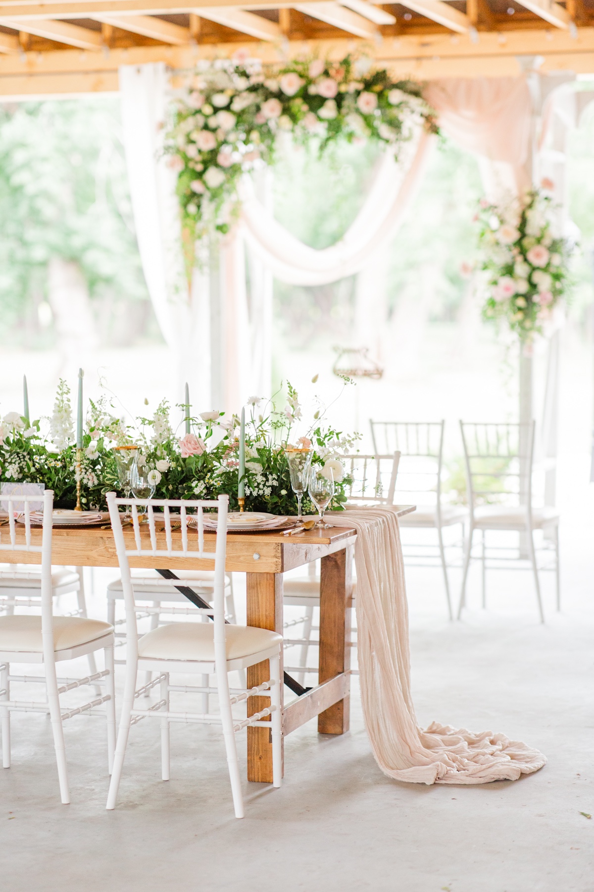 Elegant wedding reception table decorated with flowers and drapery