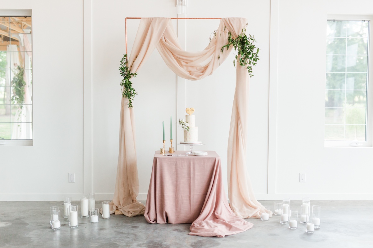 Elegant wedding cake display with draped fabric and candles