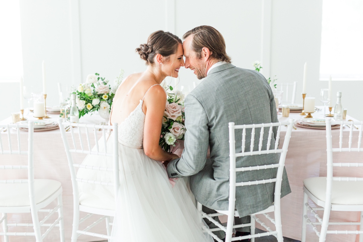 Bride and groom share a tender moment at a wedding reception
