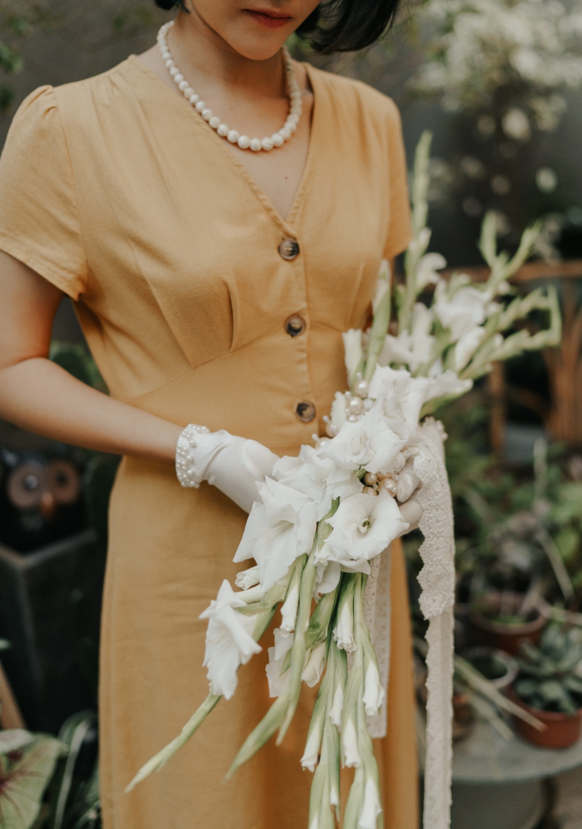 Woman in yellow dress holds white gladiolus bouquet