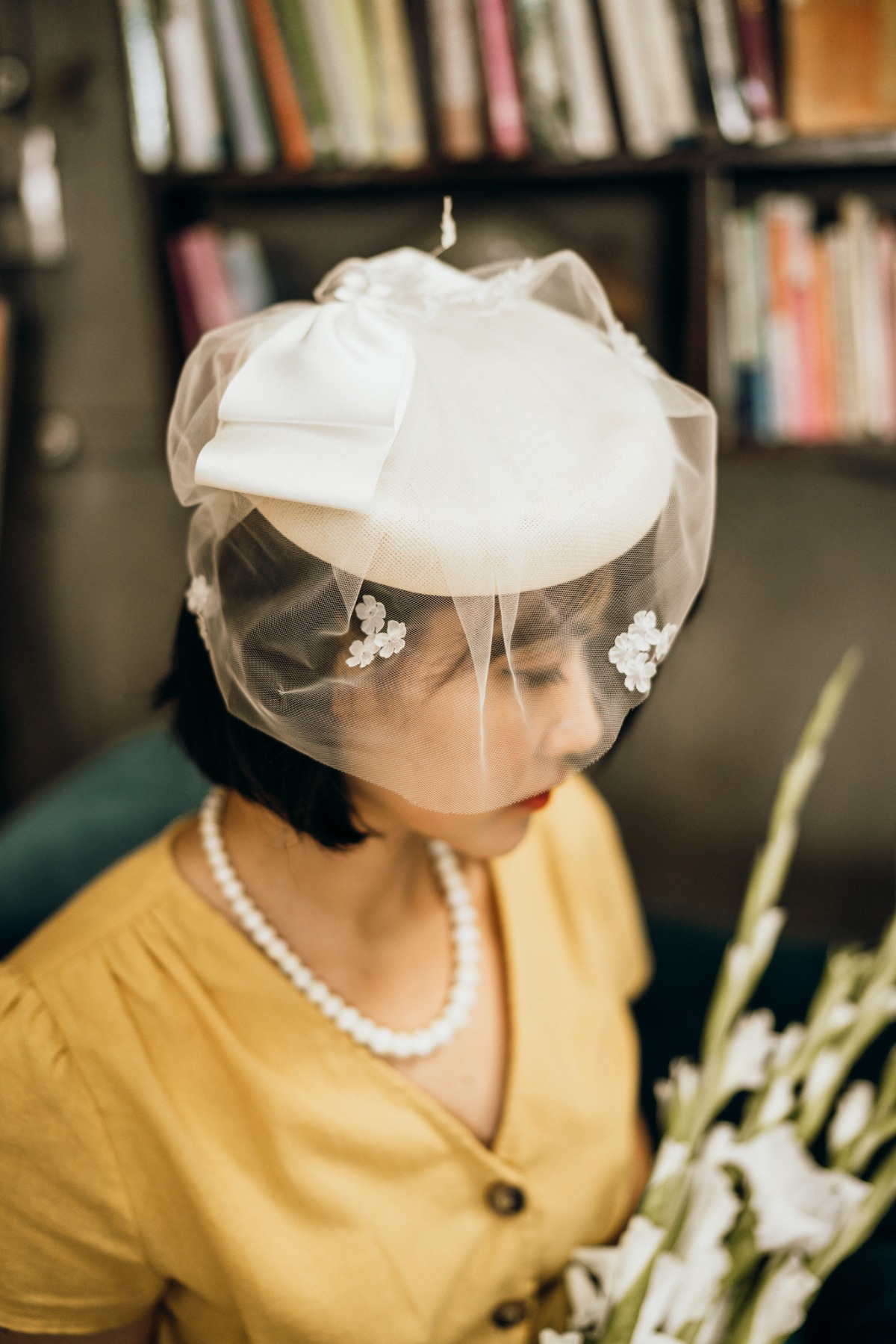 Vintage styled woman in a wedding hat and pearl necklace