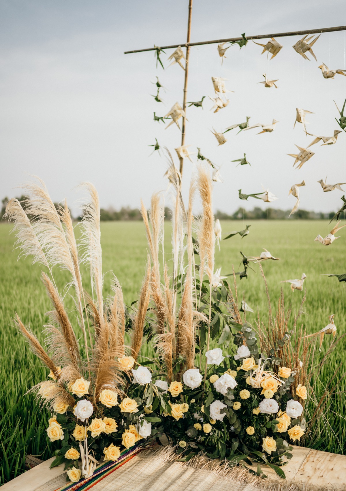 Floral display of pampas grass roses and origami birds