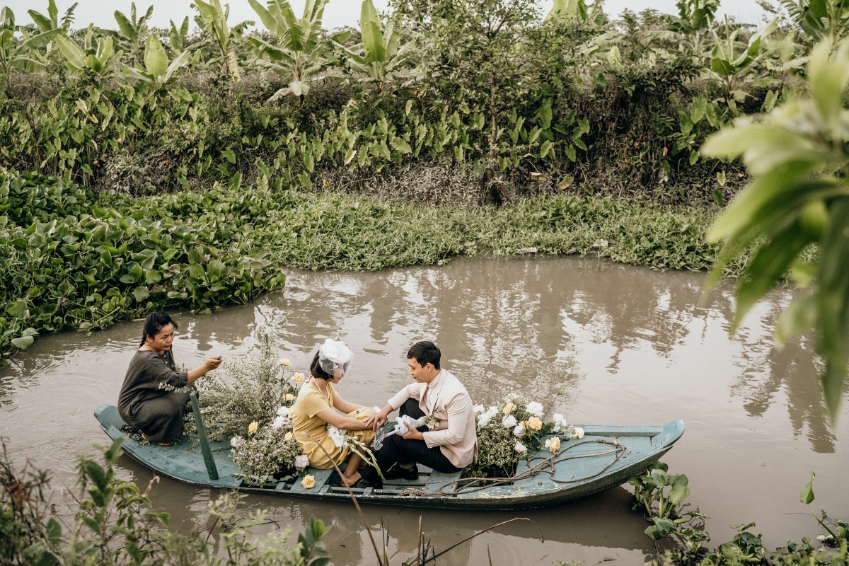 Couple in boat being decorated with flowers on river