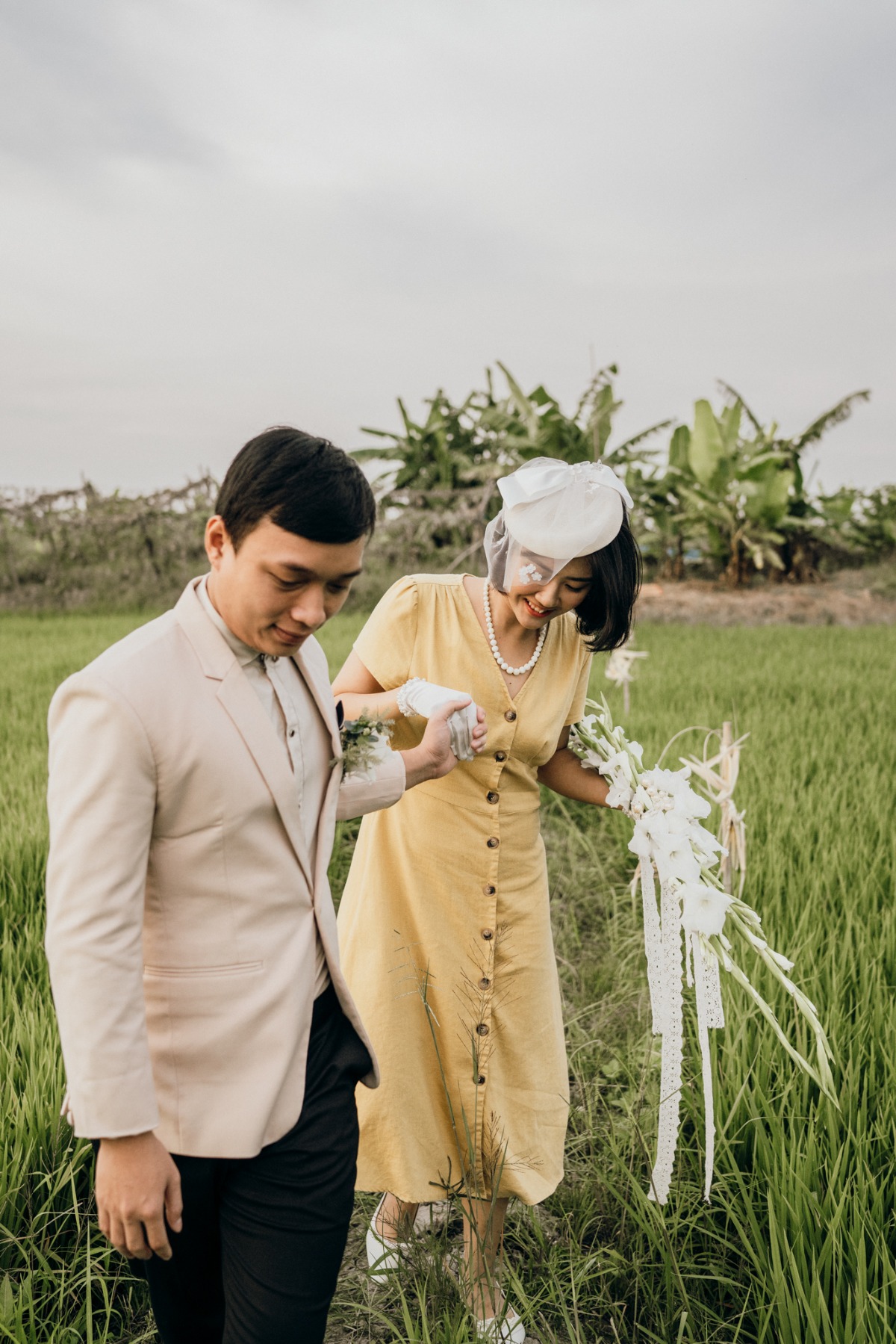 Vintage style couple walks in a rice field wedding