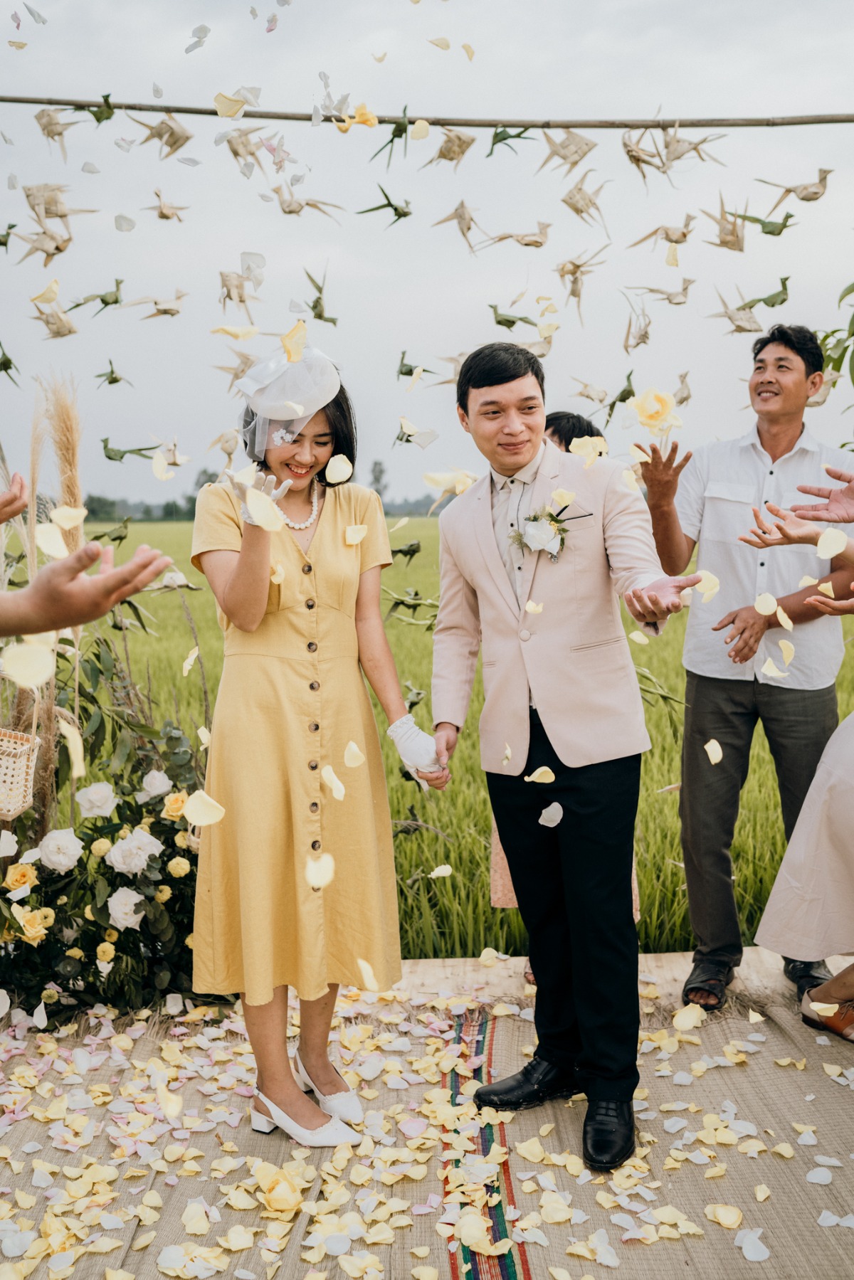 Bride and groom celebrate rural wedding with flower petals