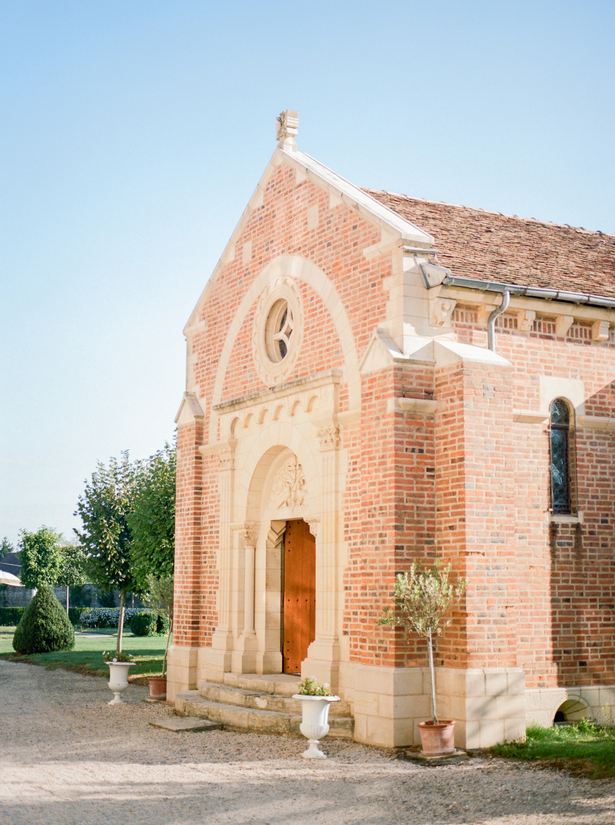 A charming brick church with a wooden door under a bright blue sky