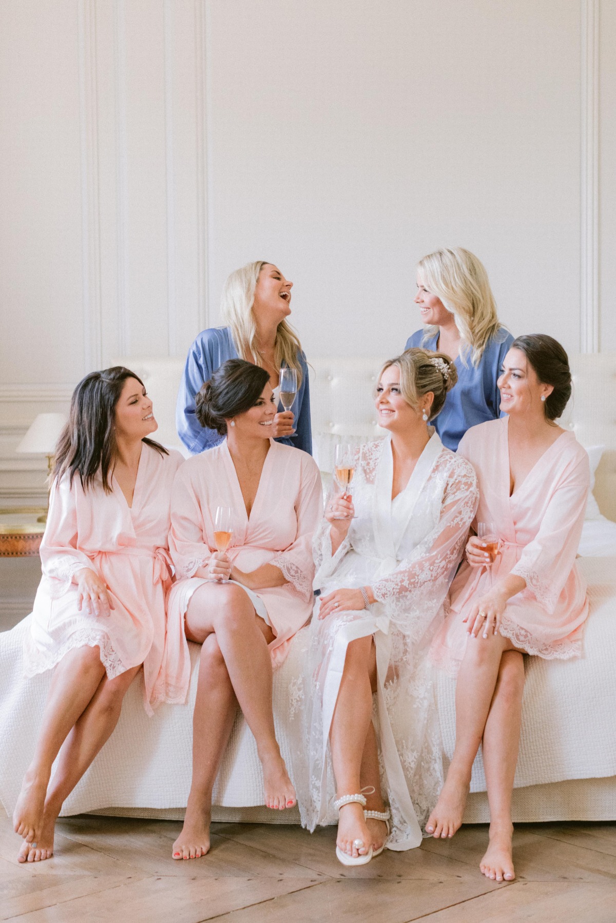 Bridesmaids laughing and toasting with champagne on wedding day