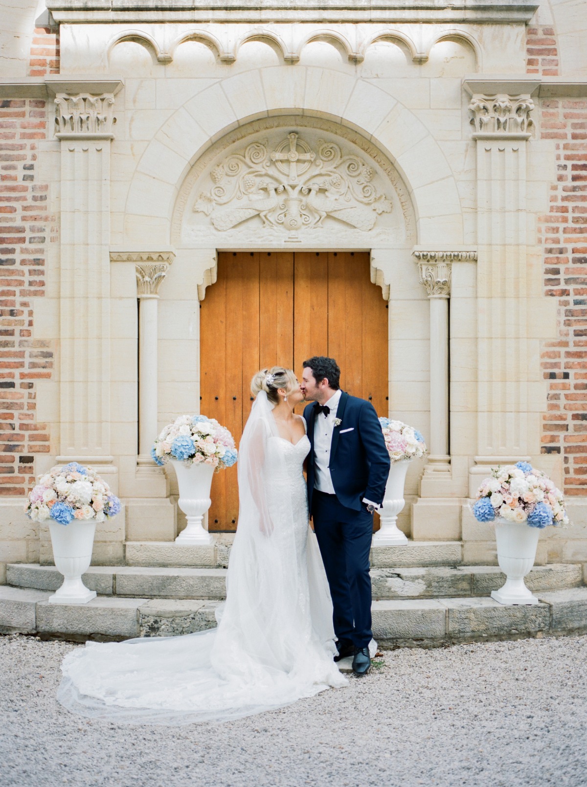 Happy couple kissing in front of a church on their wedding day