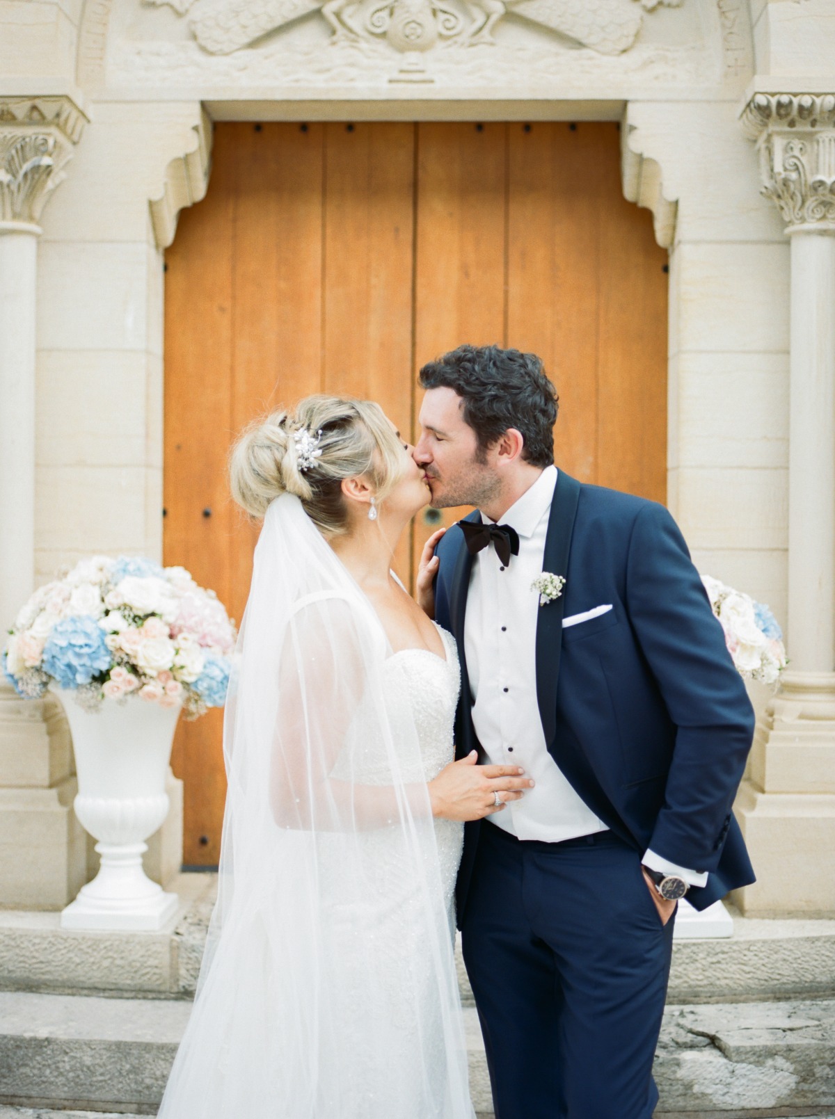 Newlyweds share a kiss outside a church on their wedding day