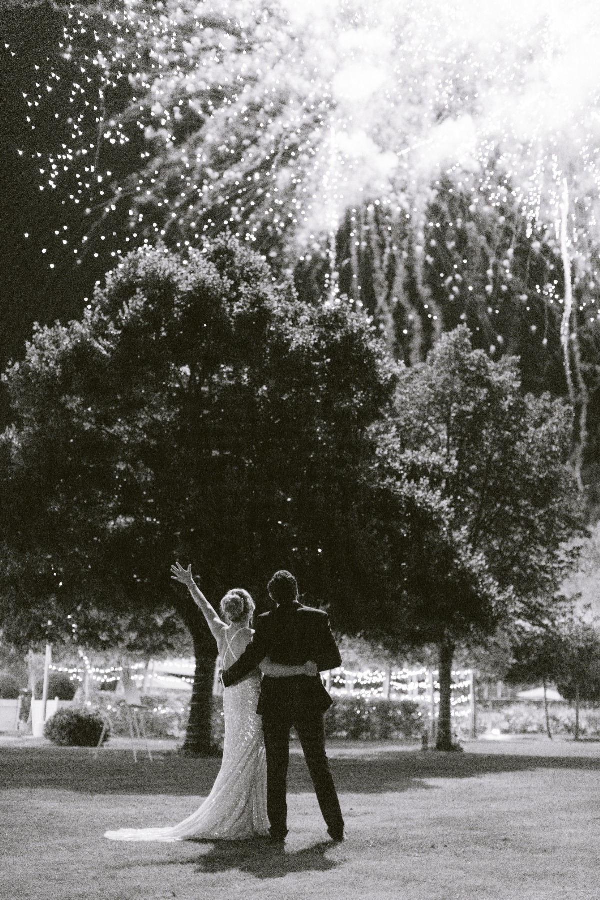 Bride and groom watch fireworks on their wedding night celebration