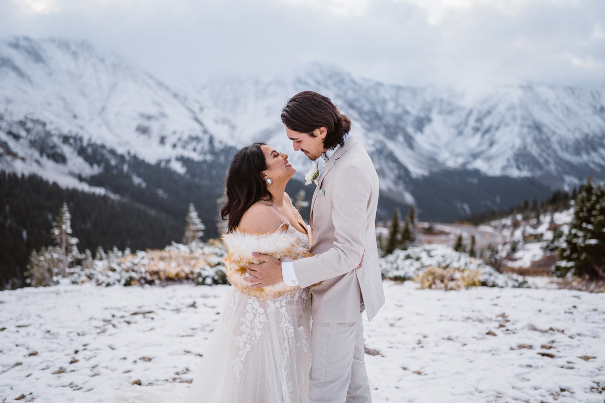 Newlyweds share a loving gaze in a snowy mountain landscape