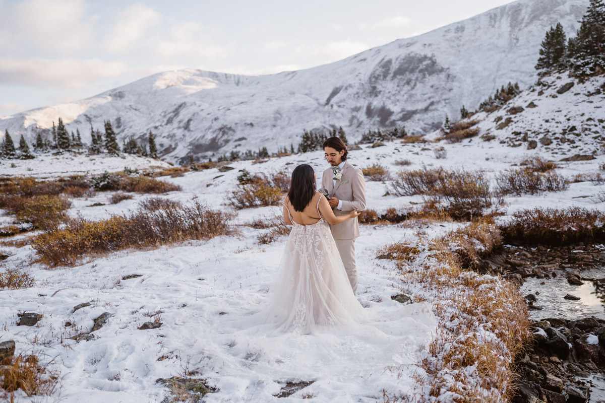 Couple getting married in snowy mountain wedding setting