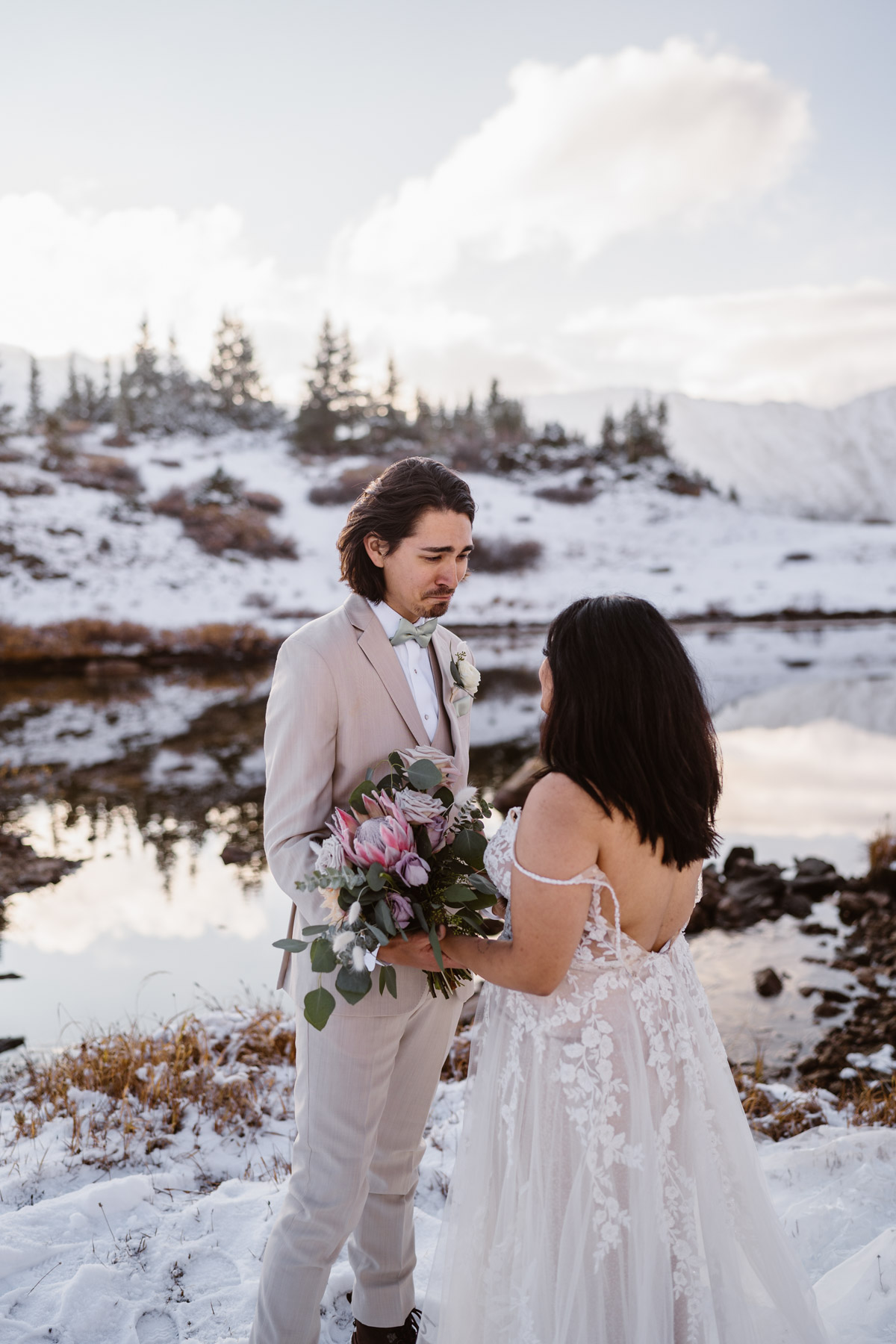 Wedding couple in the mountains by a snow-covered lake