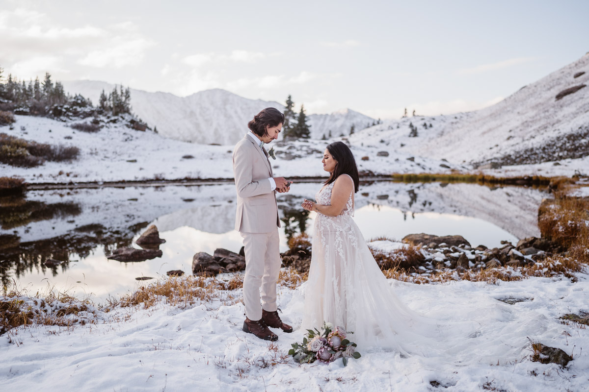 Wedding couple exchanging vows in a snowy mountain landscape