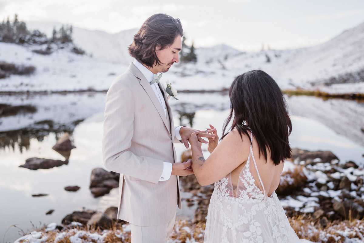 Bride and groom exchanging rings at mountain wedding ceremony